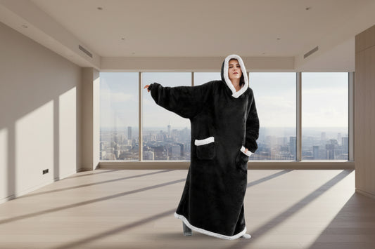 Person wearing a black and white hooded blanket with a measurement label on a white background