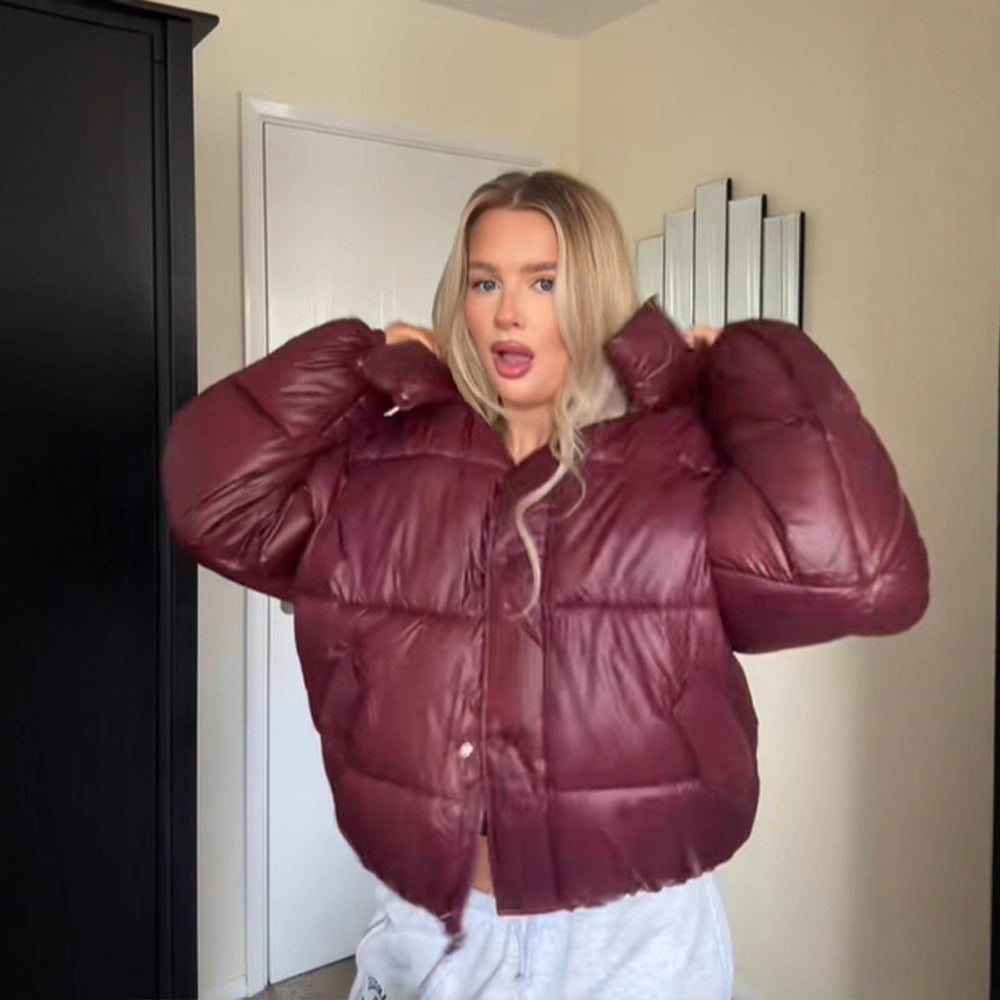 Person wearing a maroon puffer jacket indoors.