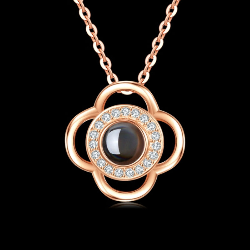 Rose gold necklace with a black gemstone and diamond accents on a black background