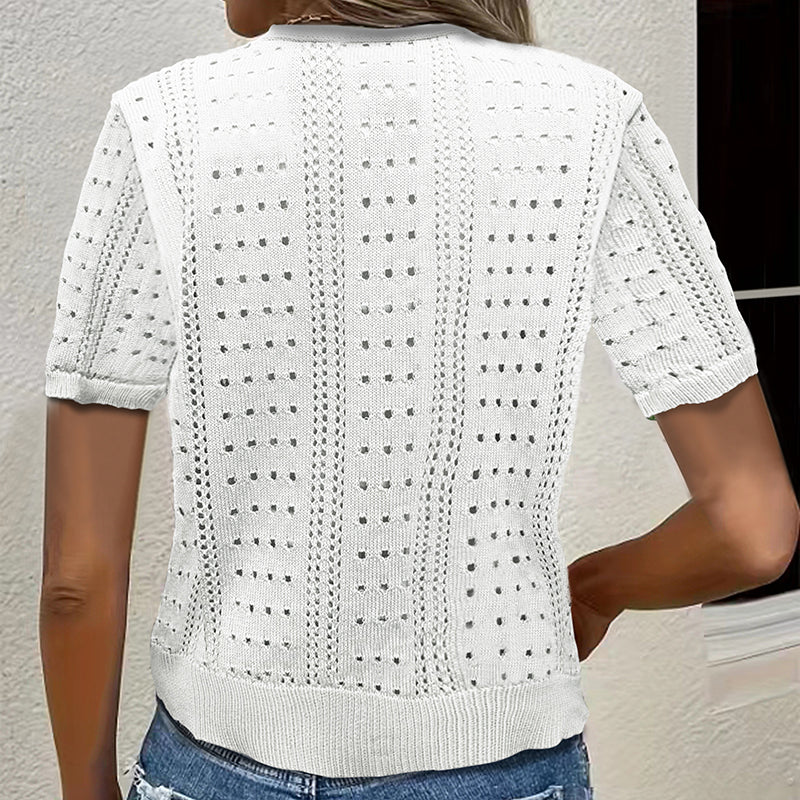 White knitted cardigan worn by a person against a neutral background