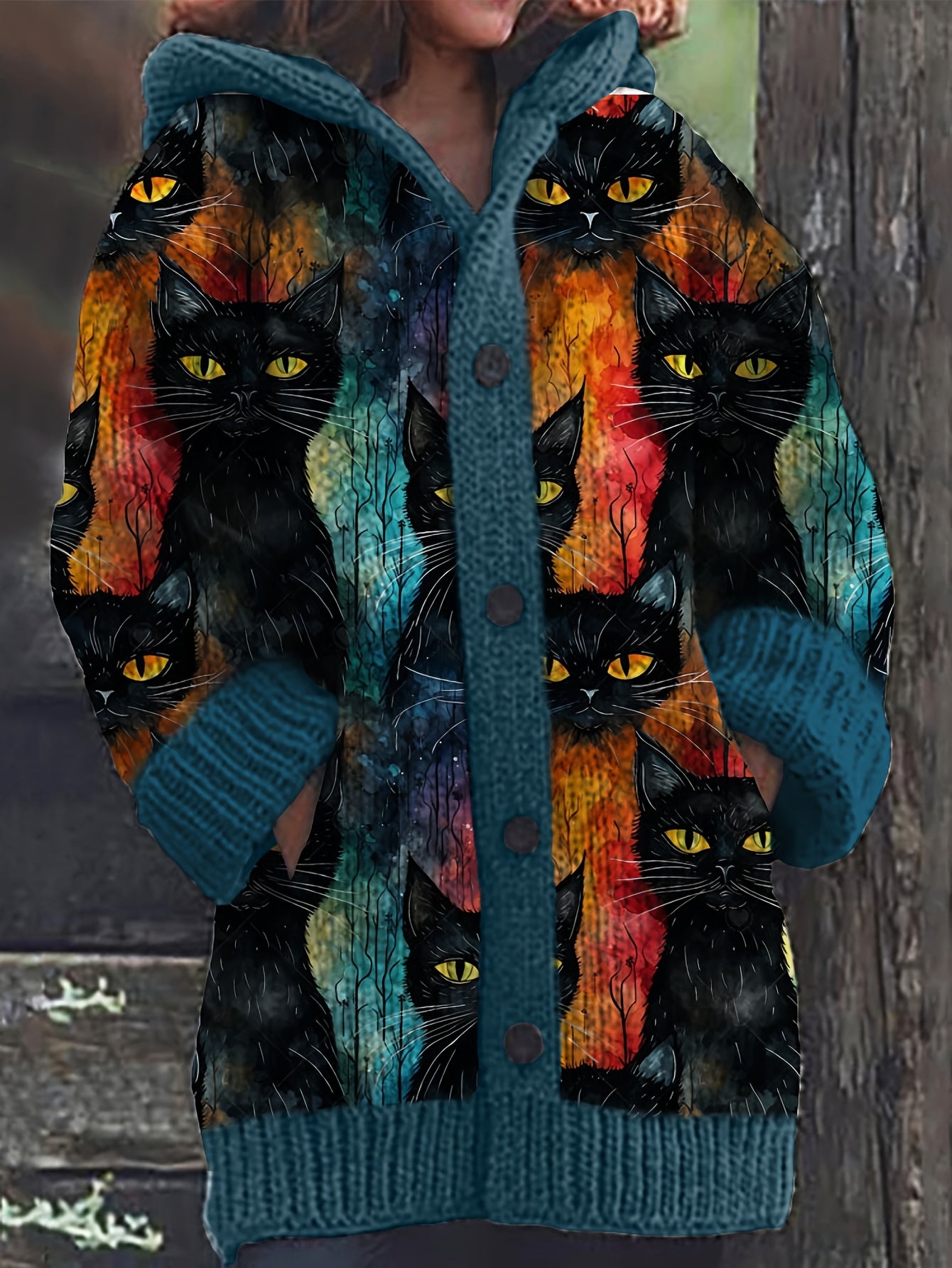 Colorful cardigan with black cat pattern on a wooden background