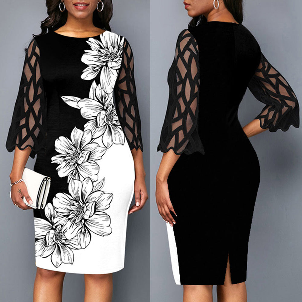 Black dress with floral design and sheer sleeves on a gray background