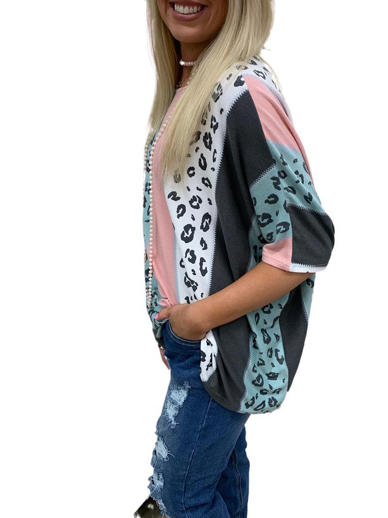 Person wearing a colorful patterned cardigan with a white background