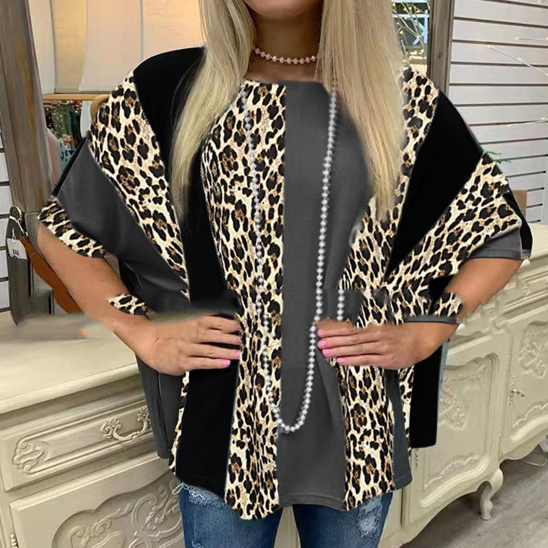 Person wearing a leopard print cardigan over a black top with a pearl necklace.