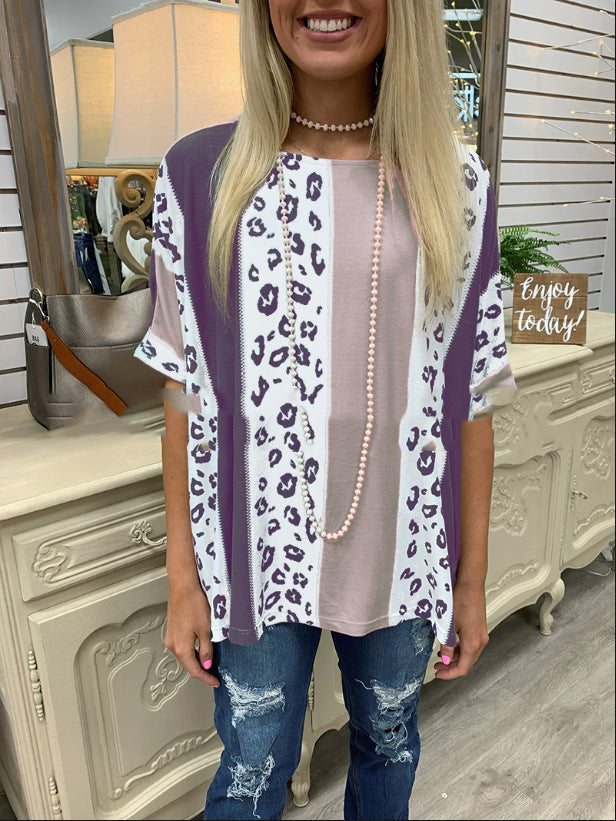 Woman wearing a leopard print cardigan over a pink top with blue jeans, standing in a store.