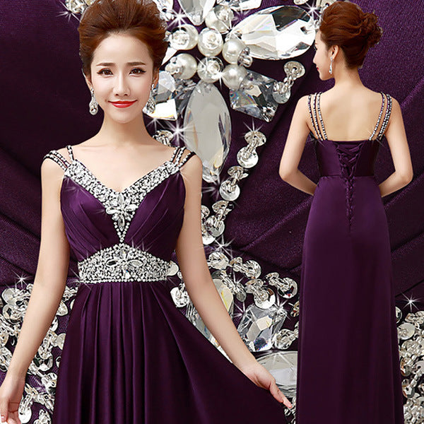 Woman wearing a purple evening gown with silver embellishments, standing against a decorative background.