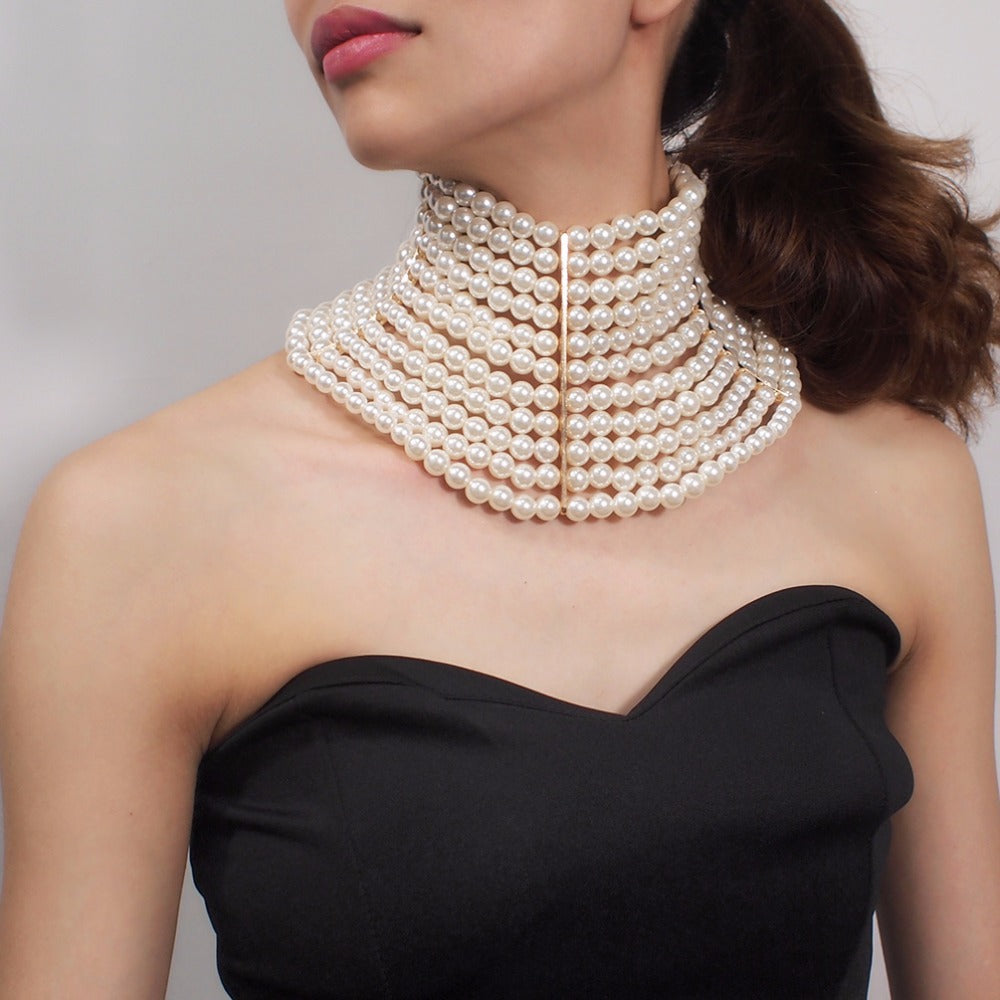 Woman wearing a luxurious pearl necklace against a neutral background