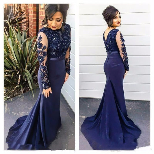 Navy blue evening gown with lace sleeves worn by a woman outdoors.