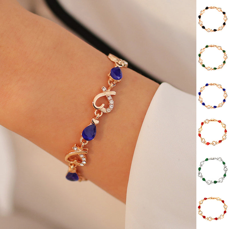 Gold bracelet with blue stones on a wrist, with color options displayed.