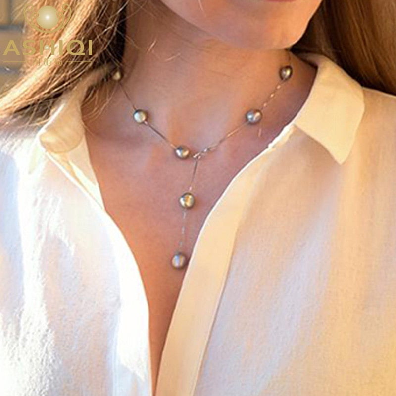 Pearl necklace worn by a person with a blurred background