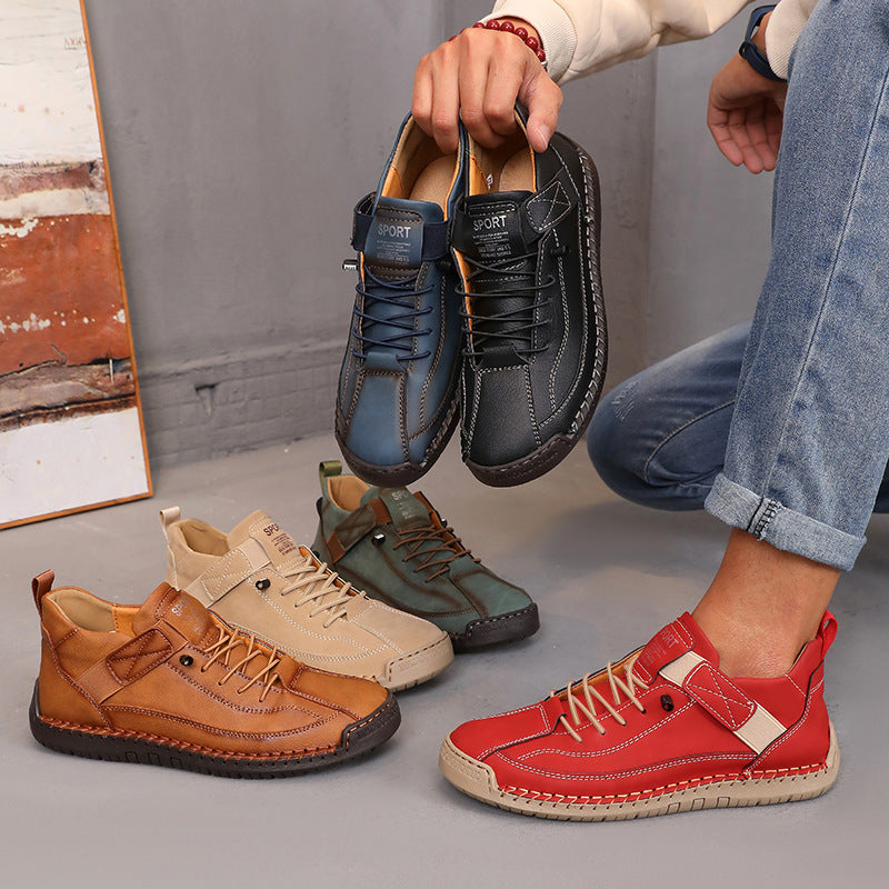 Person holding a pair of black shoes with other shoes on the ground.