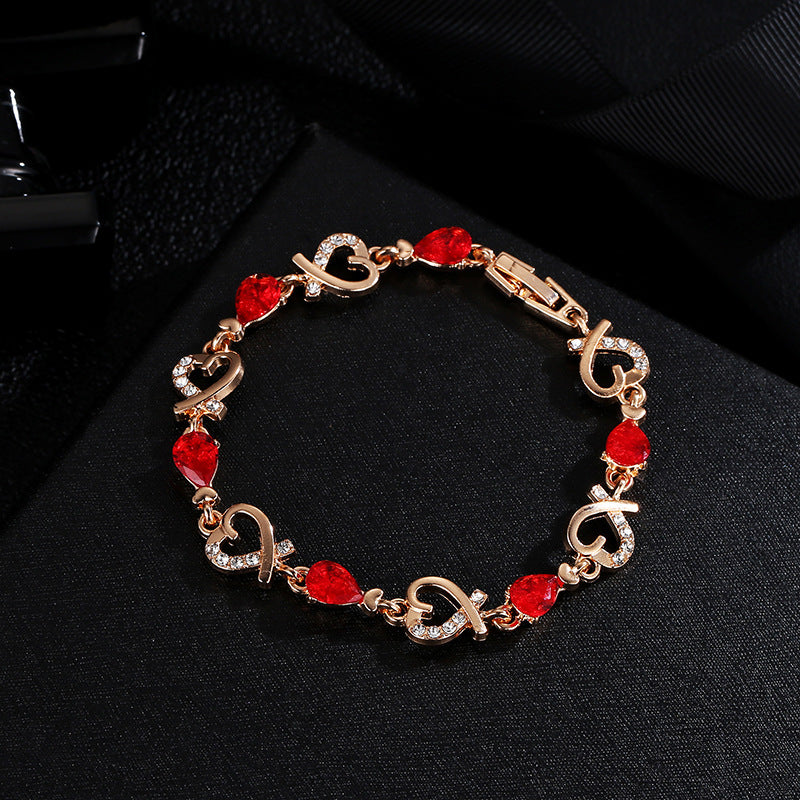 Gold bracelet with red gemstones on a black background