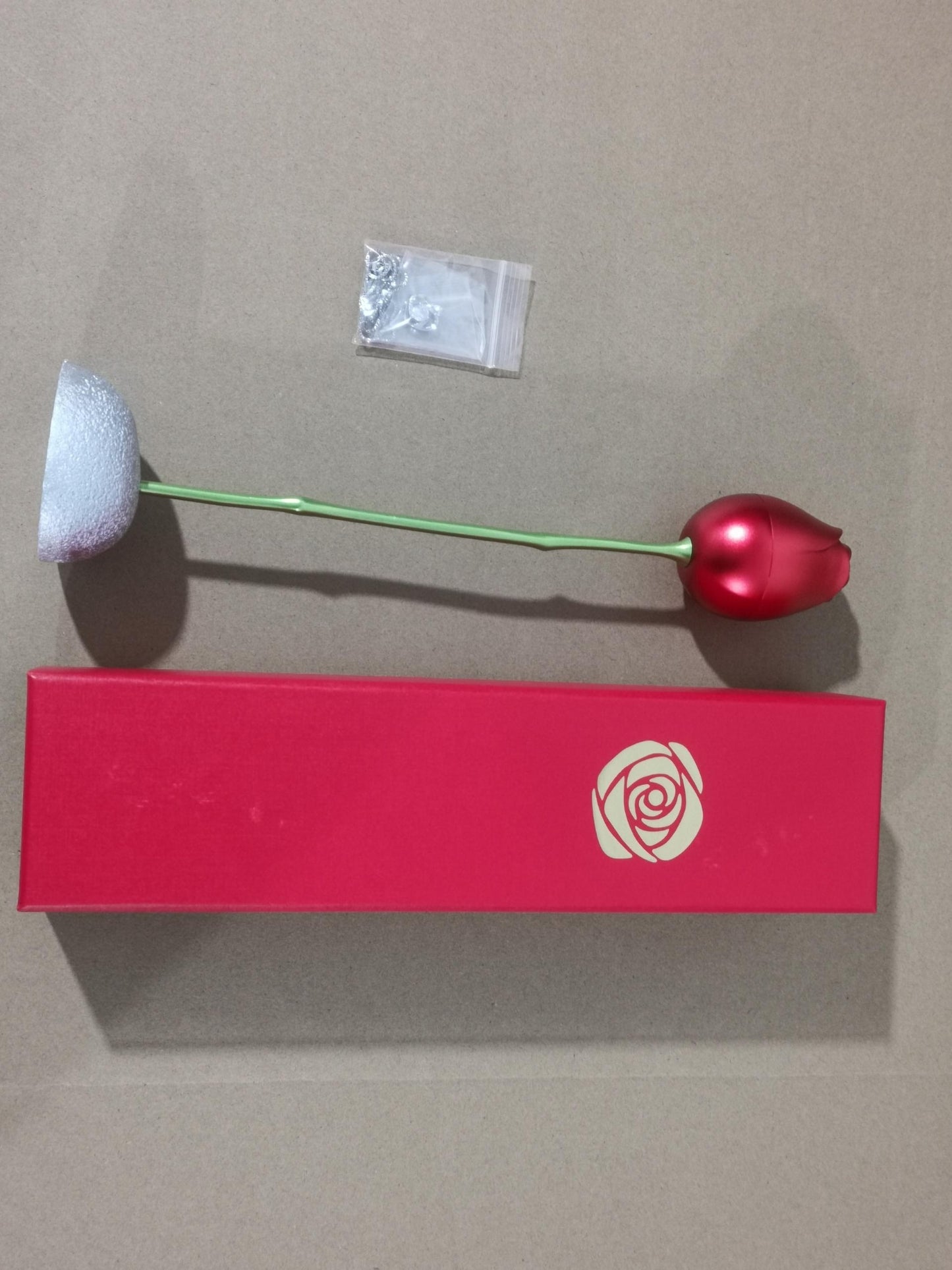 Makeup brush with red handle and white bristle head on a gray background