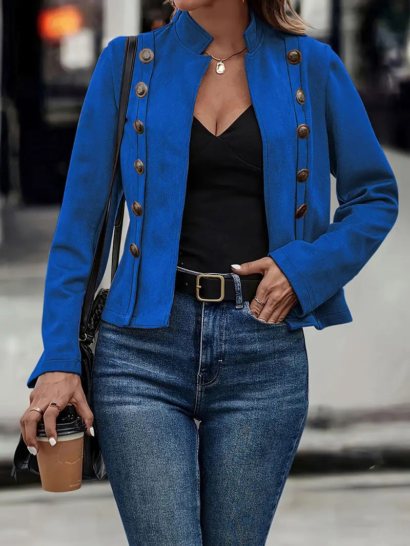 Person wearing a blue jacket with button details, black top, and jeans, holding a coffee cup.