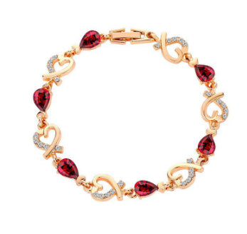 Gold bracelet with red gemstones on a white background