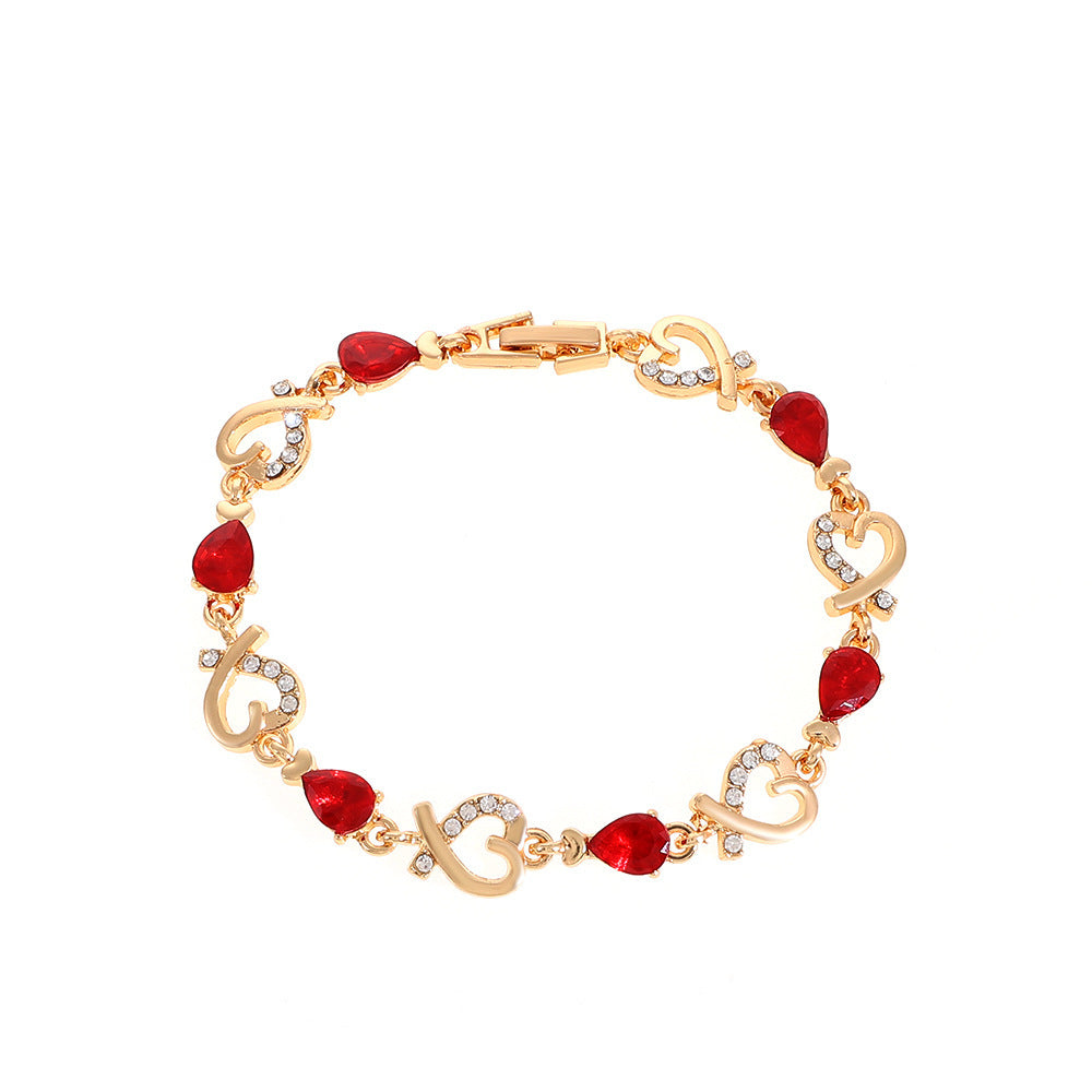Gold bracelet with red gemstones on a white background