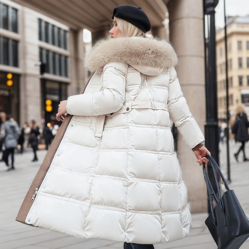 Woman wearing a white puffer coat with a fur-lined hood in an urban setting.