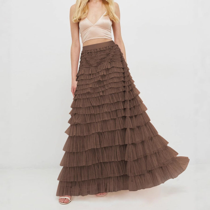 Woman wearing a long brown tiered skirt on a white background