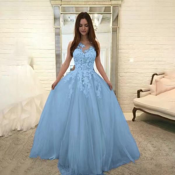 Woman wearing a light blue evening gown in a room with white walls and furniture.