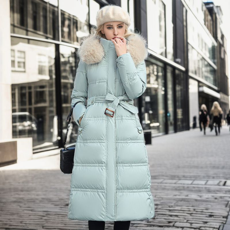 Woman wearing a light blue puffer coat with fur hood in an urban setting