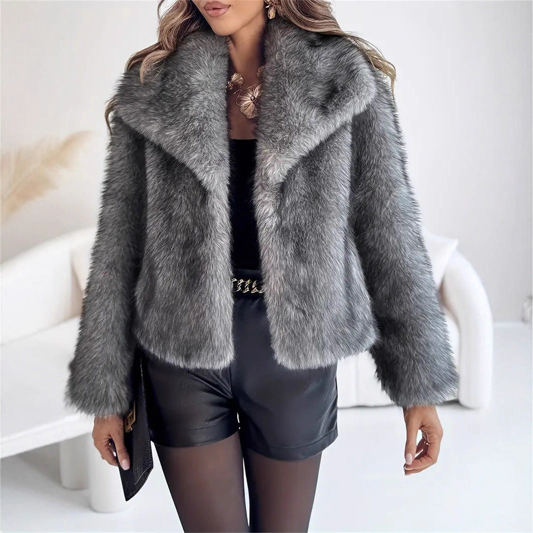 Person wearing a gray fur coat with a blurred indoor background