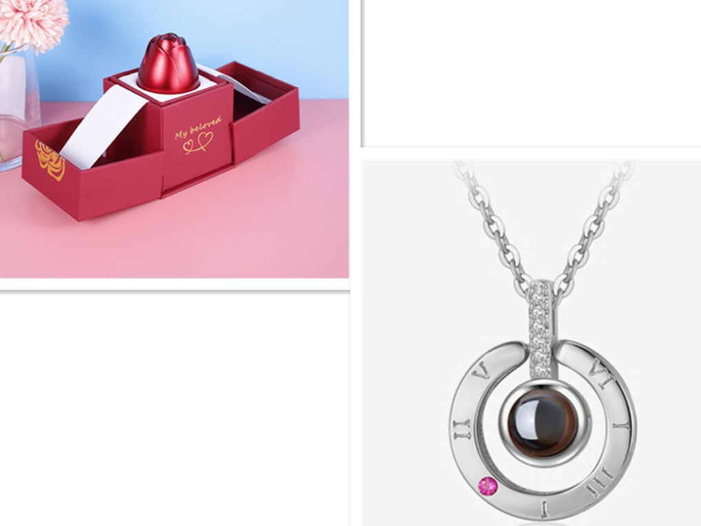 Silver necklace with a dark gemstone and pink gemstone in a red box on a pink surface.