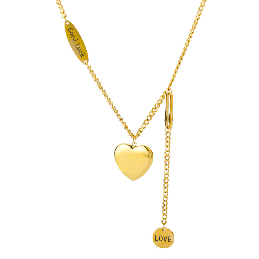 Gold necklace with heart pendant and 'LOVE' tag on a white background