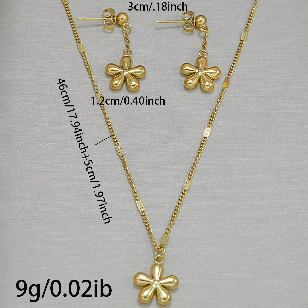 Gold necklace and earrings with measurements on a gray background