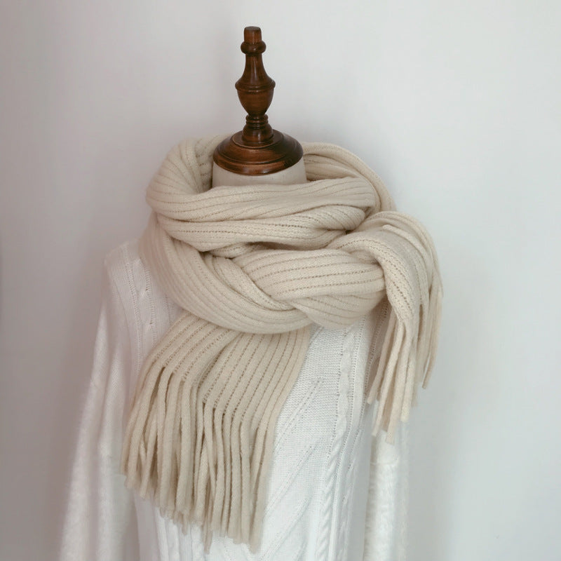 Beige scarf draped over a mannequin against a plain background
