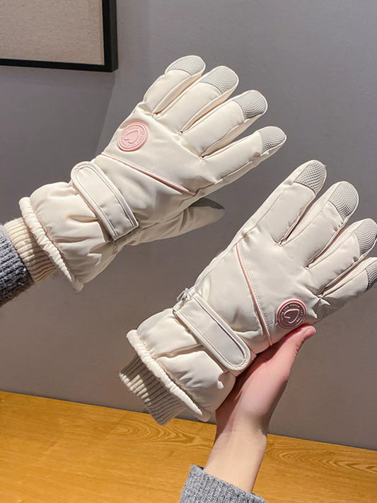 Pair of cream-colored gloves held by a hand against a neutral background