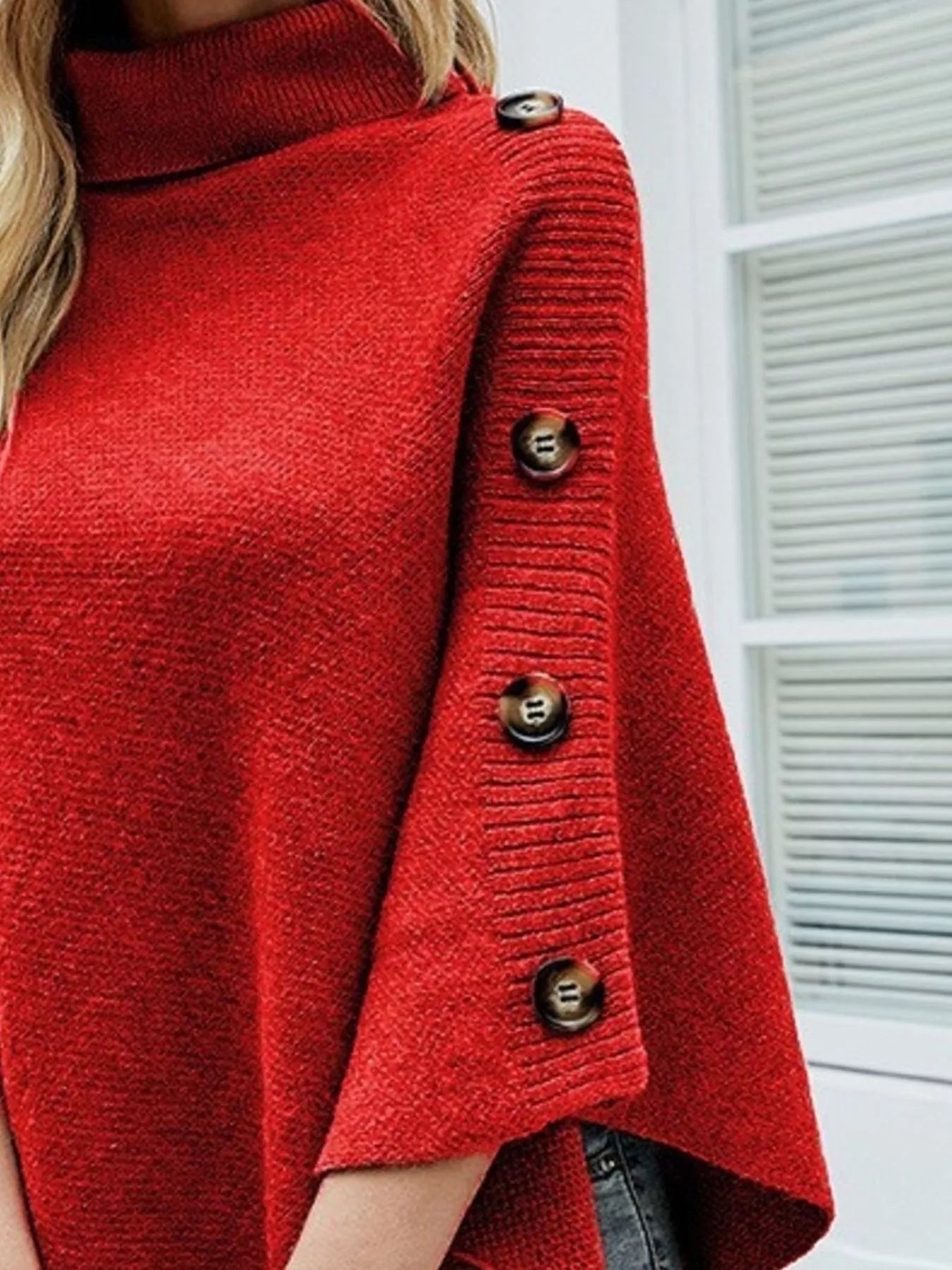 Red knitted cardigan with button details on a white background
