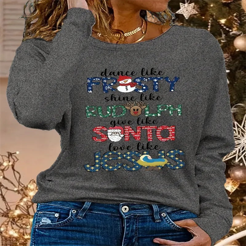 Gray sweatshirt with Christmas-themed text in front of a decorated Christmas tree.