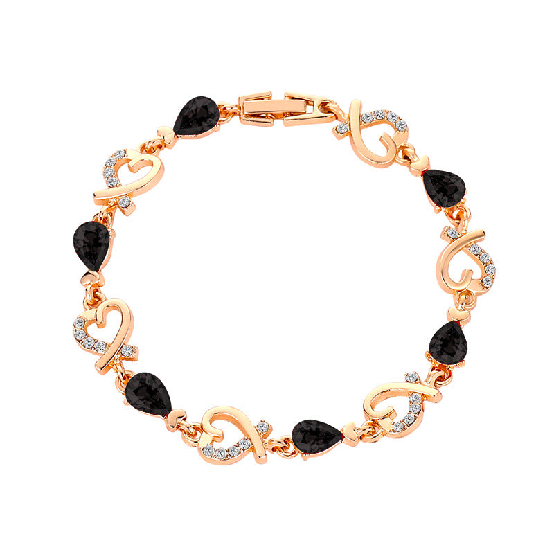Rose gold bracelet with black gemstones and clear stones on a white background
