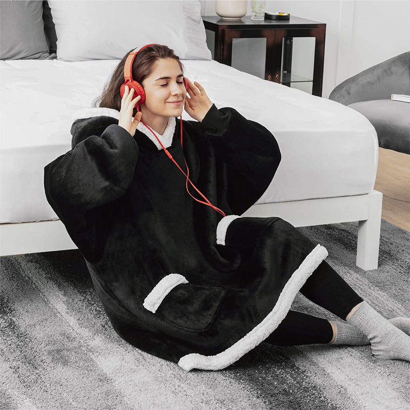 Person wearing a black and white robe sitting on the floor with red headphones.