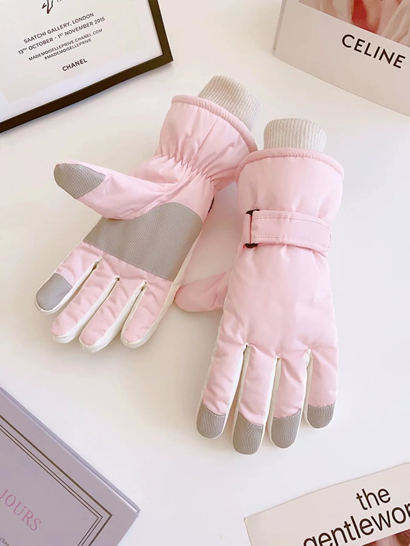 Pink gloves with gray tips on a light surface