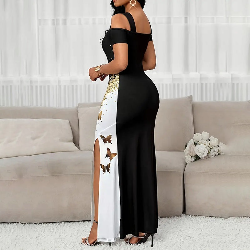 Woman in a black and white dress with butterfly patterns standing in a living room.