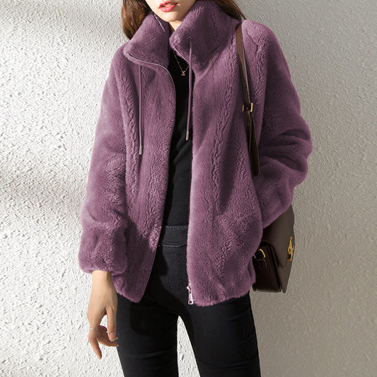 Person wearing a purple fleece jacket with a neutral background