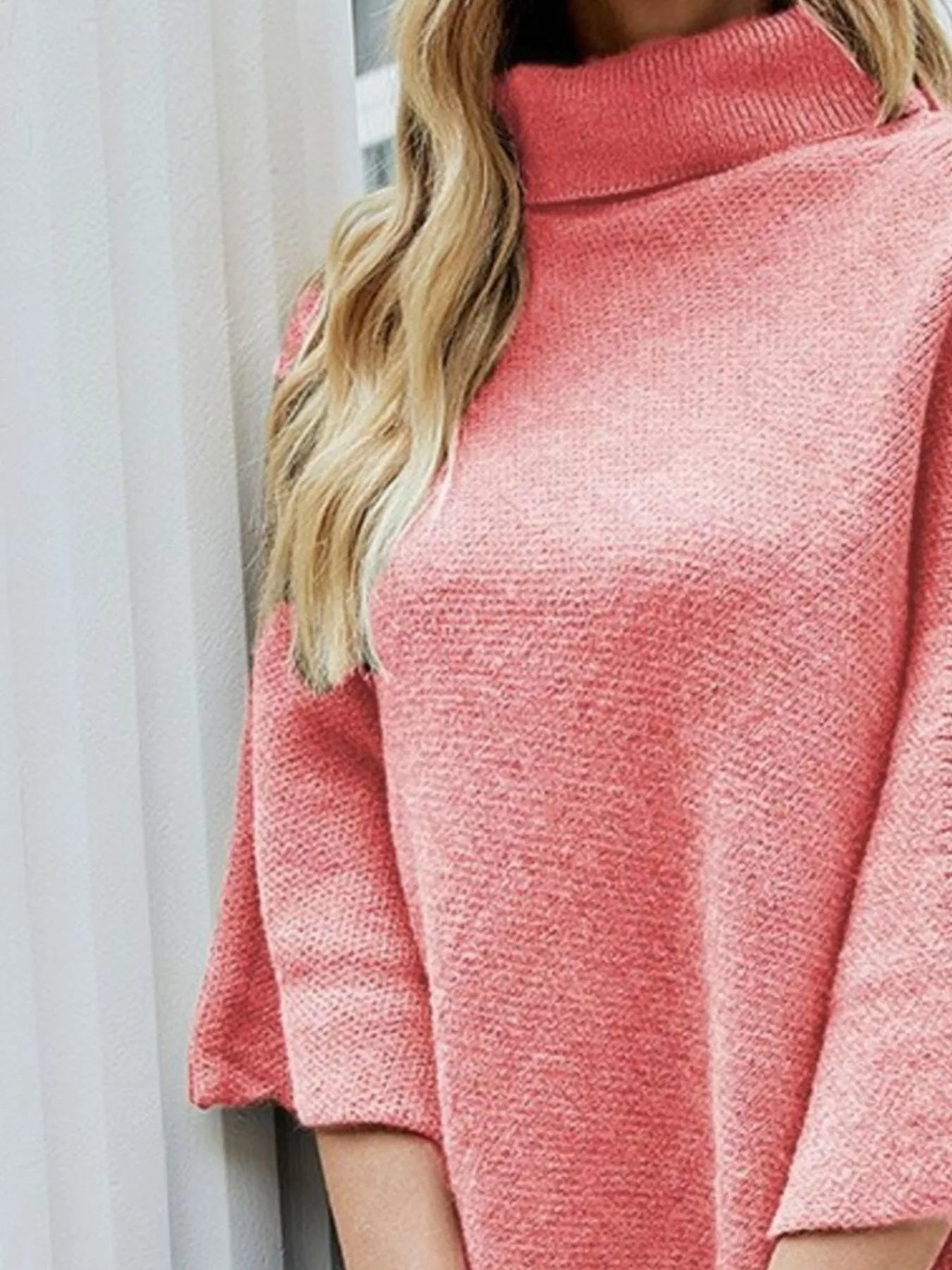Close-up of a pink textured sweater worn by a person with light-colored hair.