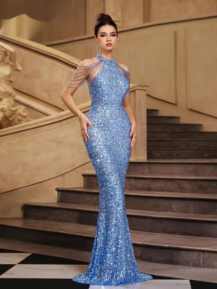 Woman in a blue sequin gown standing on a staircase
