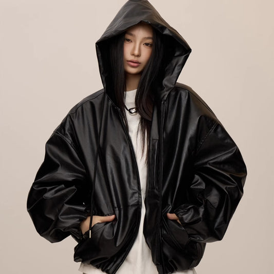 Person wearing a black raincoat on a beige background