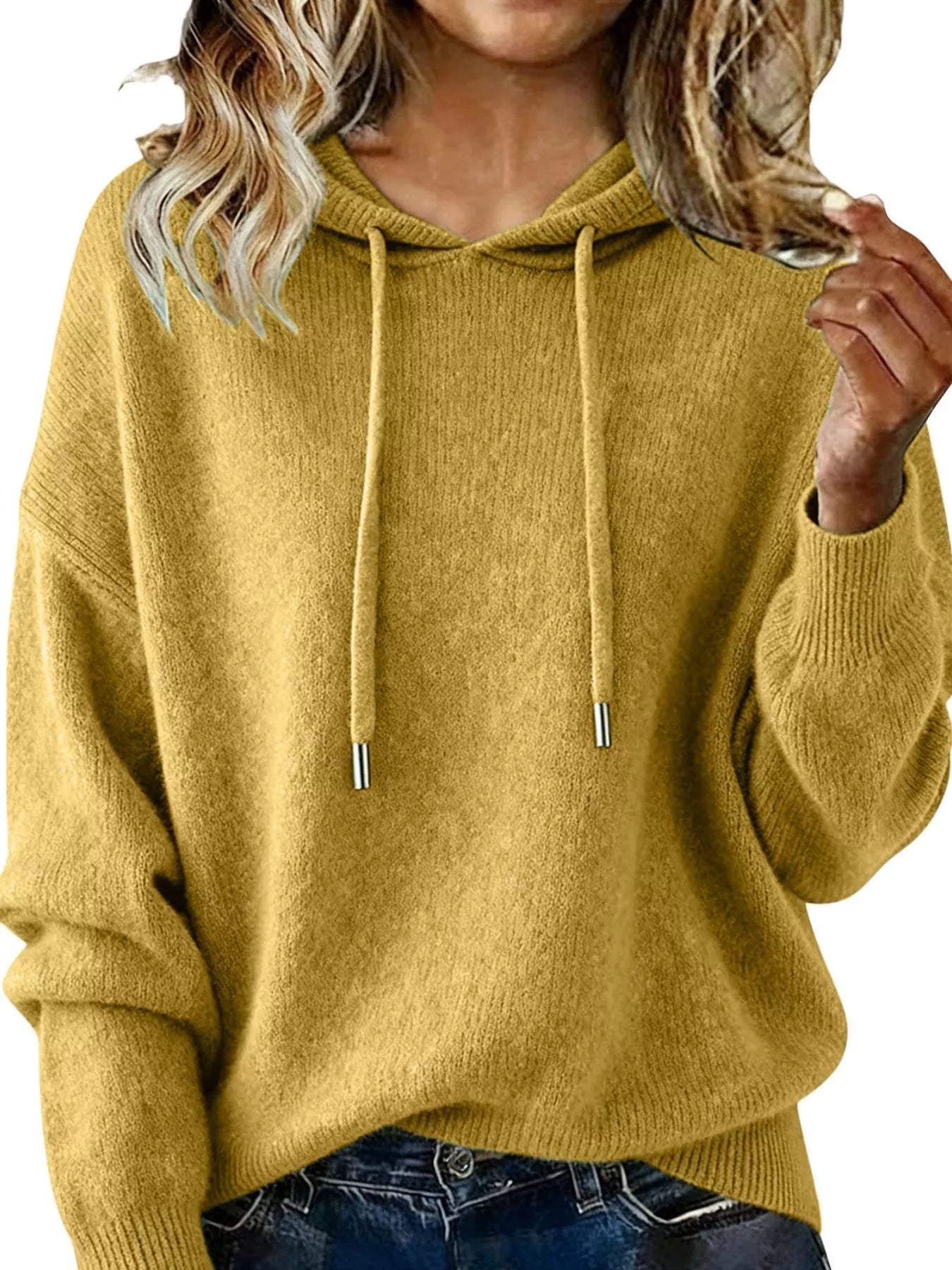 Mustard yellow hoodie worn by a person, with a focus on the garment.