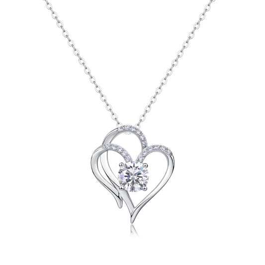 Silver heart-shaped necklace with a central gemstone on a white background