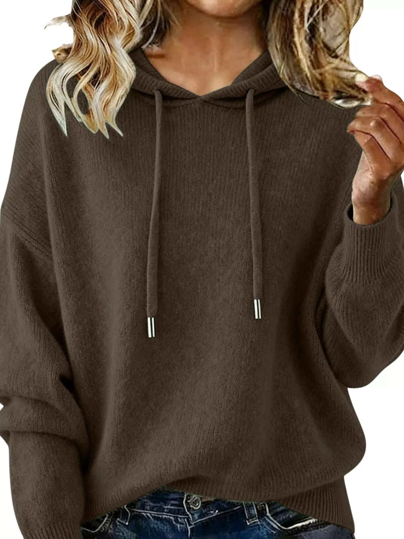 Brown hoodie worn by a person with blonde hair, wearing blue jeans.