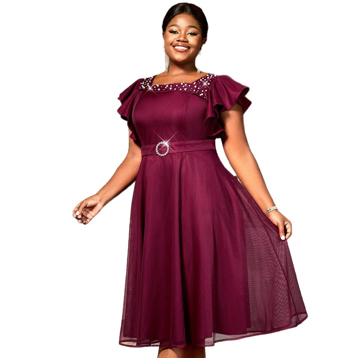 Woman wearing a burgundy dress with embellishments on a white background
