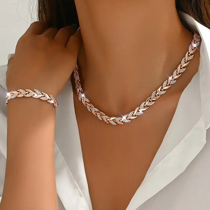 Rose gold braided necklace and bracelet on a person wearing a white shirt.