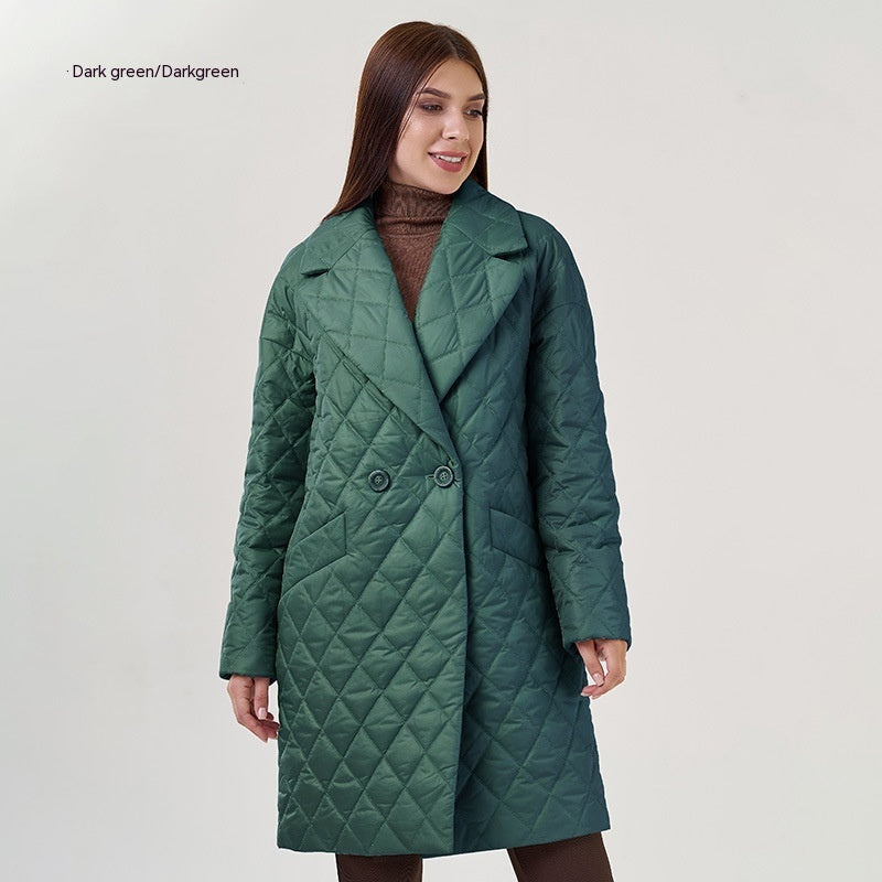 Woman wearing a dark green quilted coat on a light gray background