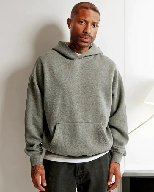 Man wearing a gray hoodie against a plain background