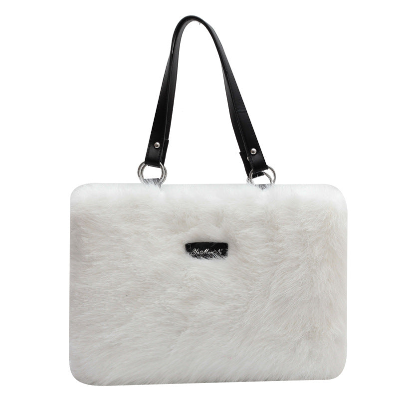 White fur handbag with a black handle on a white background