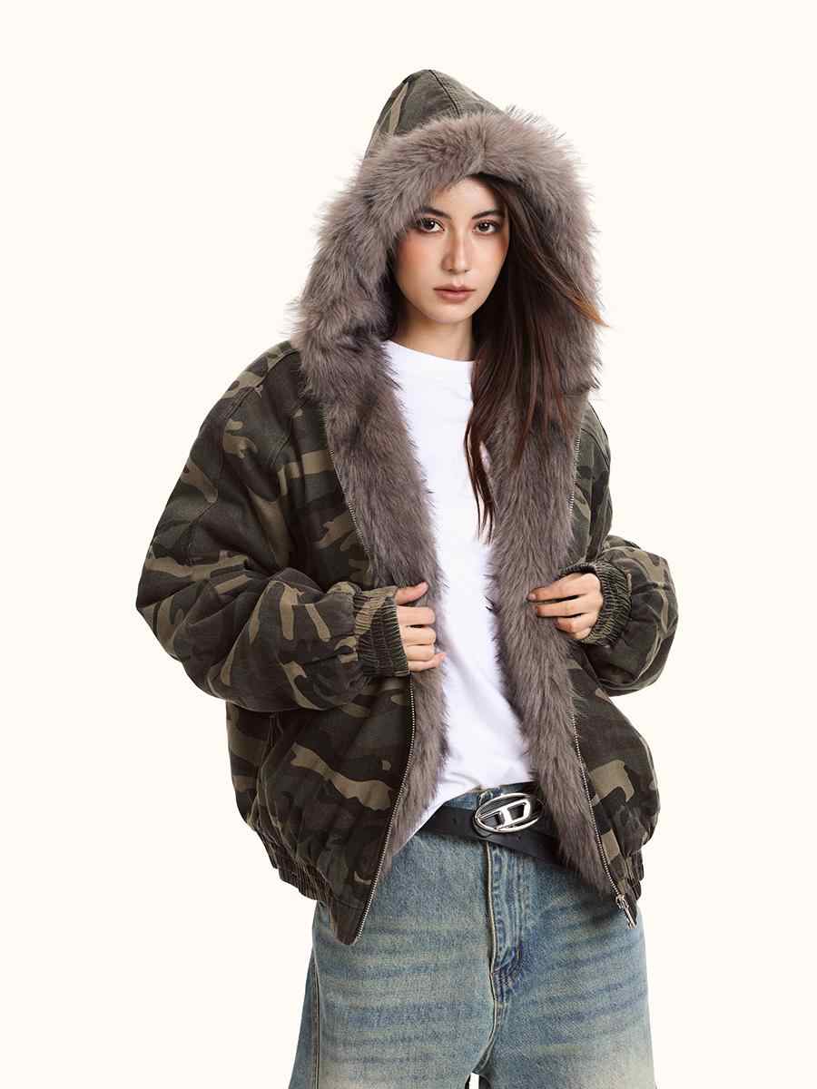 Person wearing a camouflage jacket with fur hood on a white background