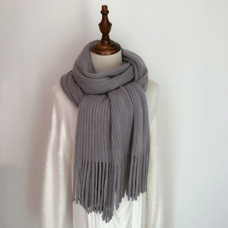 Gray scarf with fringe on a mannequin against a white background